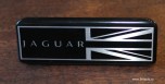 Гемма на передней панели Jaguar XJ, надпись Jaguar и британский флаг. Черный лак, серебристая надпись